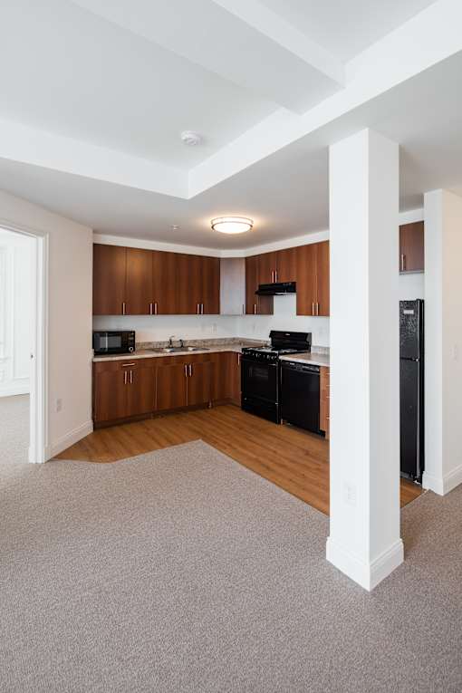 A kitchen with wooden cabinets and black appliances.