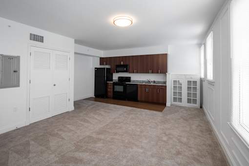 A kitchen with white walls and brown cabinets.