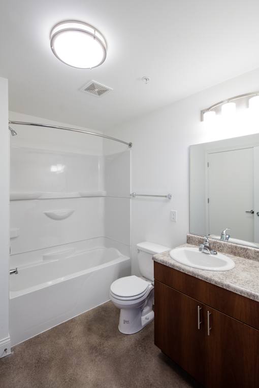 A white bathroom with a toilet, sink, and bathtub.