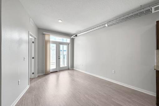 A spacious room with a slanted ceiling and a doorway leading to another room.