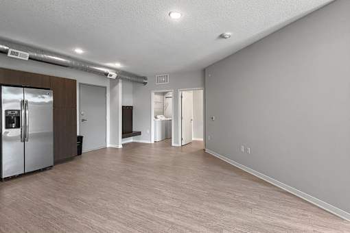 A spacious kitchen area with a refrigerator, sink, and cabinets.