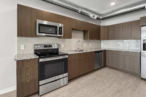 A kitchen with brown cabinets and a black stove top oven.