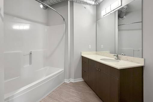 A bathroom with a white tub and sink.