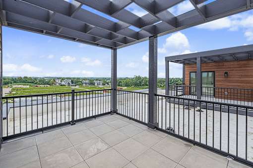 Private balcony with overhead pergola and city views at The Flats at West Glen Apartments, West Des Moines