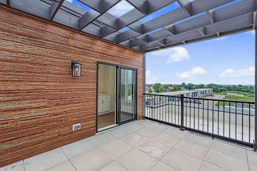 Private balcony with pergola and city views at The Flats at West Glen Apartments, Iowa