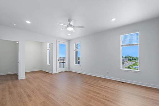 Spacious living room with ceiling fan and balcony access at The Flats at West Glen Apartments, West Des Moines, 50266