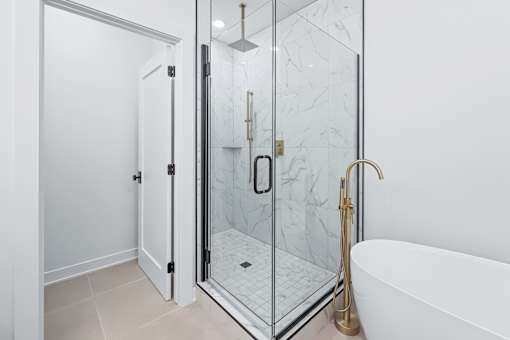 Luxury bathroom with glass shower and freestanding tub at The Flats at West Glen Apartments, West Des Moines