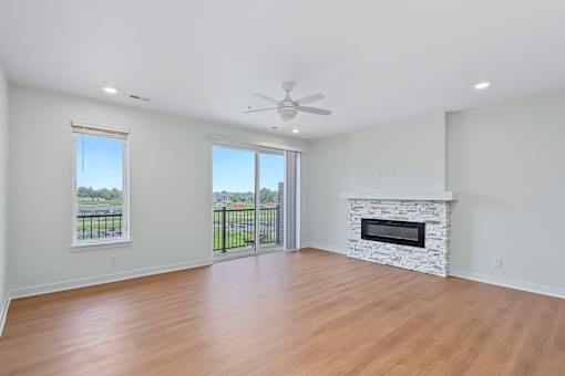 Open living room with stone fireplace and lake views at The Flats at West Glen Apartments, West Des Moines, IA 50266