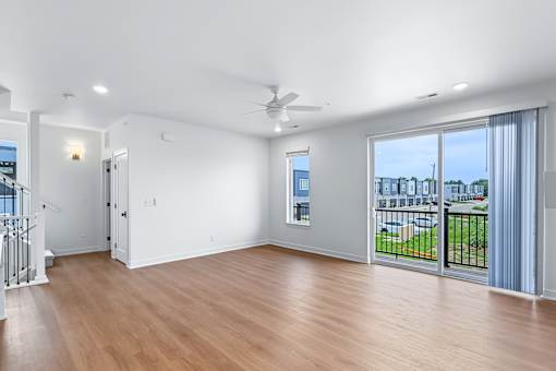 Open living space with balcony and wood flooring at The Flats at West Glen Apartments, West Des Moines, 50266