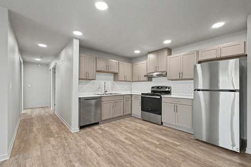 A kitchen with wooden floors and stainless steel appliances.