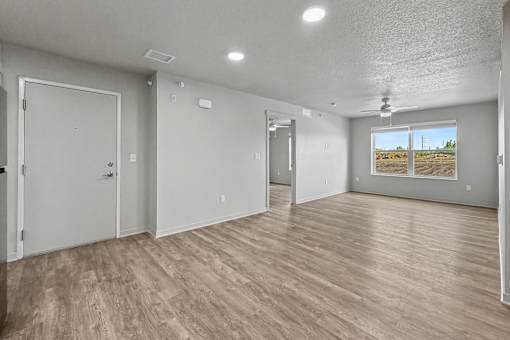 A room with wooden flooring and white walls.