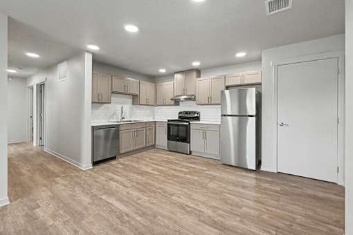 A kitchen with wooden floors and stainless steel appliances.