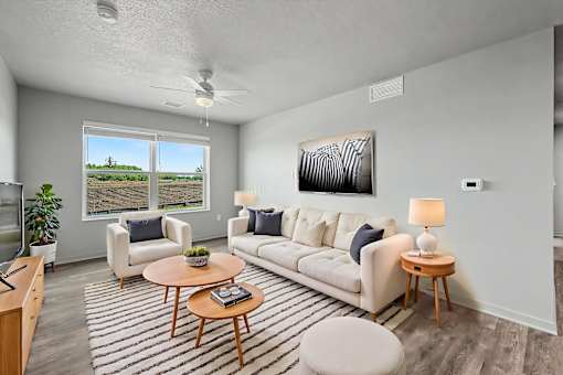 A living room with a white couch, a wooden coffee table, and a ceiling fan.