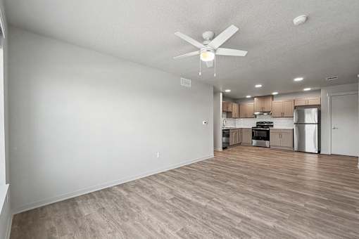 A room with a ceiling fan and wooden flooring.