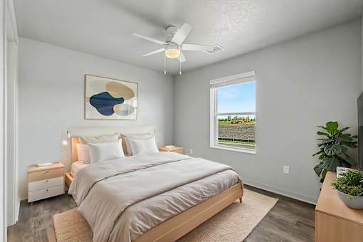 A bedroom with a large bed and a ceiling fan.