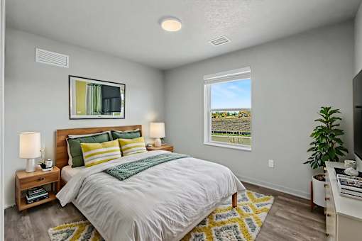 A bedroom with a bed, nightstands, and a window.