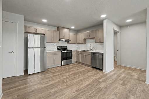 A kitchen with wooden floors and white walls.
