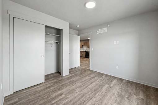 A room with a white door and a wooden floor.