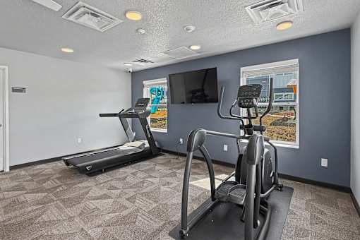 A room with a treadmill and a stationary bike.