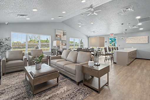 A living room with a grey sofa, a coffee table, and a ceiling fan.