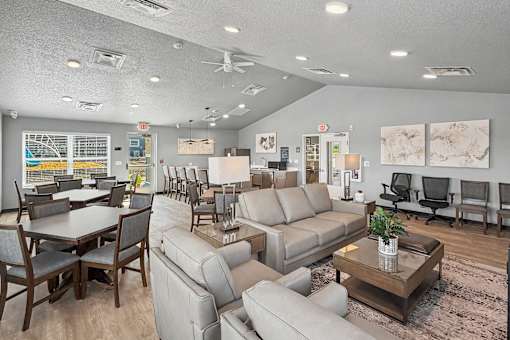 A spacious living room with a variety of seating options and a dining table.