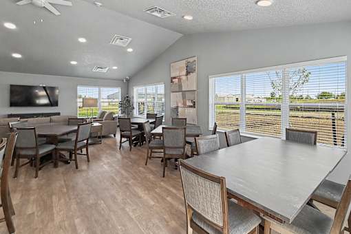 A dining room with a large table and chairs.