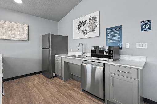 A kitchen with stainless steel appliances and a wooden floor.