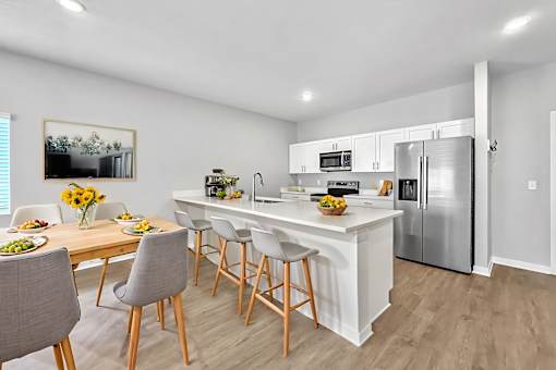 A modern kitchen with a dining table and chairs.
