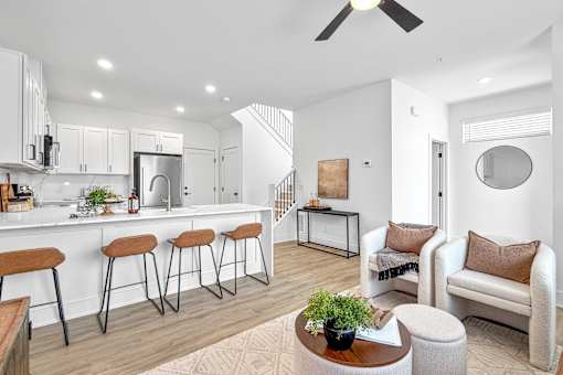 A modern kitchen with white cabinets and a bar area with stools.