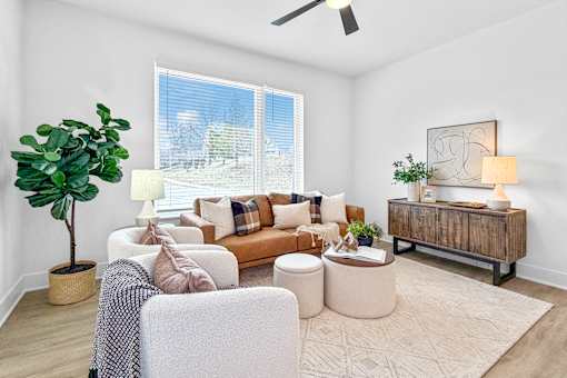 A spacious living room with a couch, chair, and potted plant.
