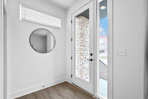 The front entrance with a mirror, leading to the spacious living room.