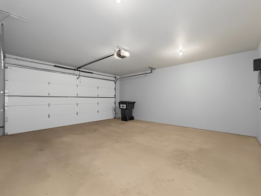 A large empty room with a trash can in the middle.