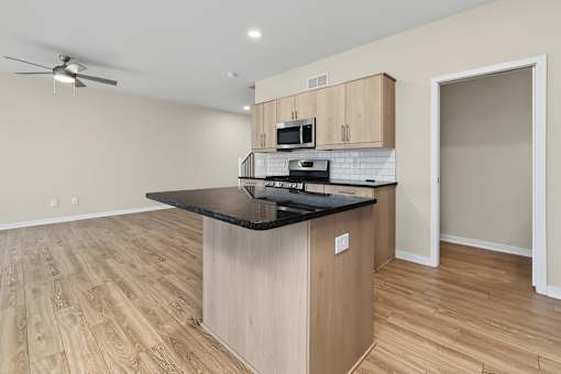 A kitchen with a black countertop and wooden cabinets.