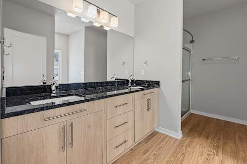 A bathroom with a sink, mirror, and wooden cabinets.