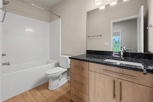 A white toilet sits in a bathroom with wooden cabinets.