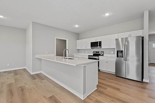 A modern kitchen with stainless steel appliances and white cabinetry.