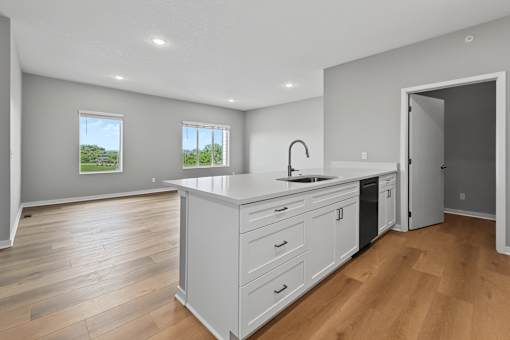A kitchen with a large island and wooden floors.