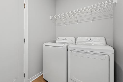 Two white front loading washing machines in a laundry room.