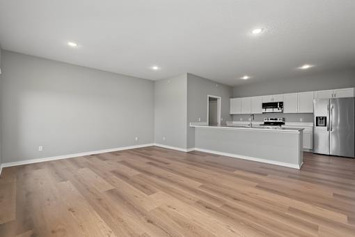 A kitchen with a refrigerator, sink, and cabinets.