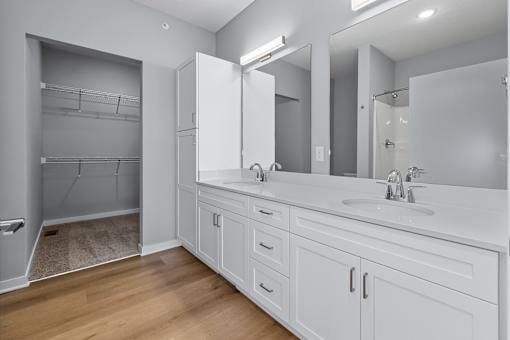 A bathroom with a sink, mirror, and cabinets.