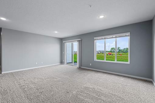 A spacious room with grey walls and carpeted floor.