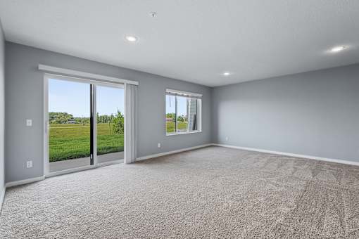 A room with grey walls and a carpeted floor with a sliding glass door.
