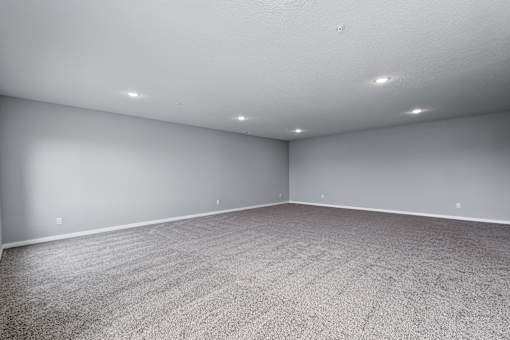 A room with grey carpet and white walls.