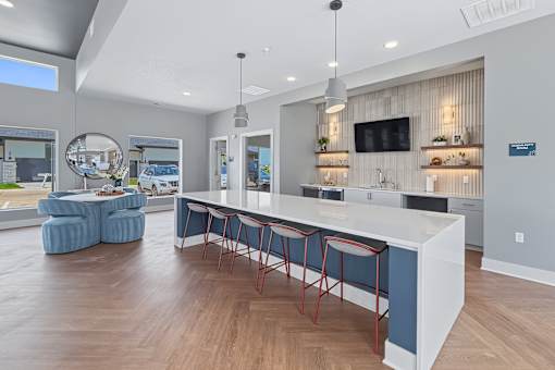 A modern kitchen with a bar area and a television mounted on the wall.