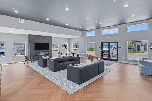 A spacious living room with a grey sofa set and a television.