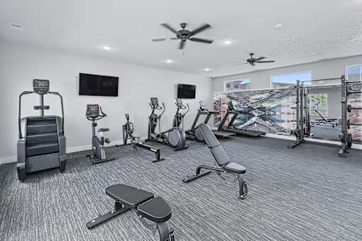 A spacious gym with a variety of equipment including treadmills, exercise bikes, and weight machines.