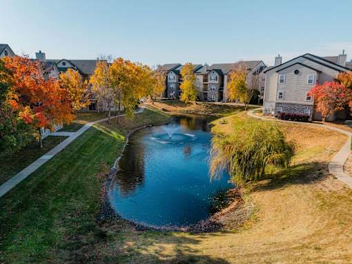 an aerial view of a pond with houses in the background at 92West, Iowa  