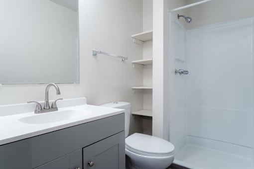 A white bathroom with a toilet and sink. at Bristol Ridge, Urbandale, 50322