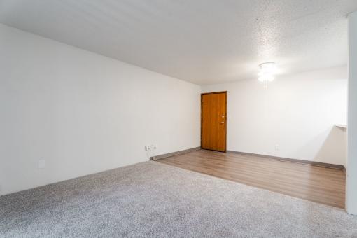 A room with a carpeted floor and a wooden door. at Bristol Ridge, Urbandale, IA, 50322