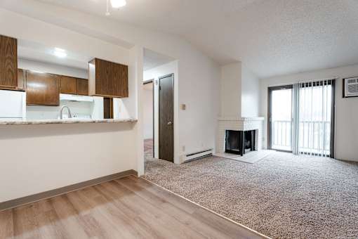 A living room with a fireplace and sliding glass doors. at Bristol Ridge, Urbandale, 50322